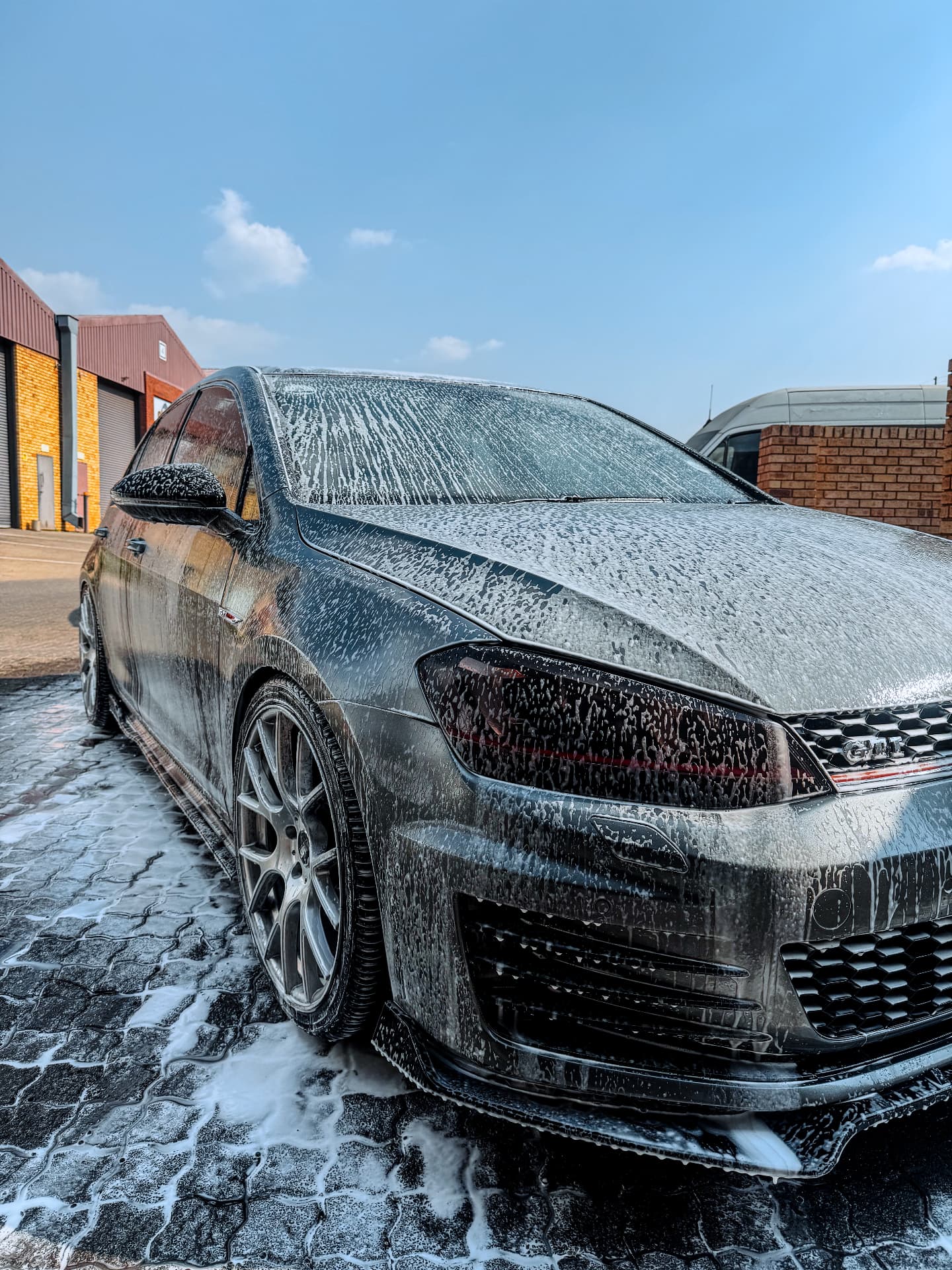 Volkswagen Golf GTI covered in pre-wash foam outside the D2 Customs studio